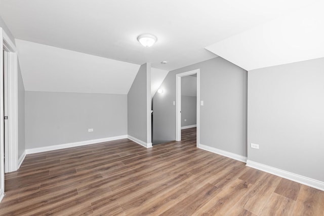 bonus room with lofted ceiling, wood finished floors, and baseboards