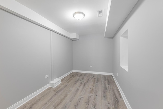 empty room with visible vents, baseboards, and wood finished floors