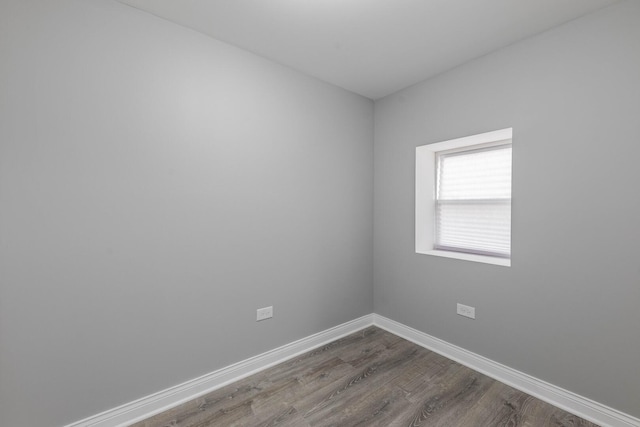 unfurnished room with dark wood-type flooring and baseboards