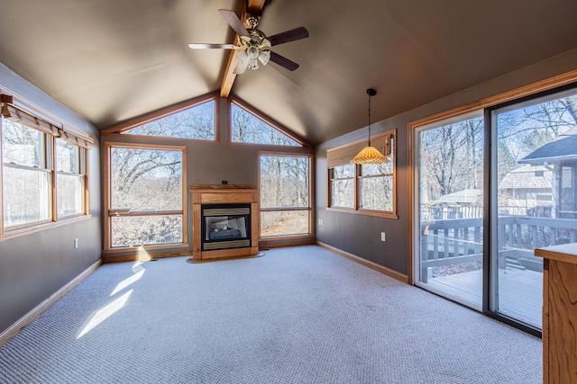 unfurnished sunroom featuring ceiling fan, a glass covered fireplace, and vaulted ceiling with beams