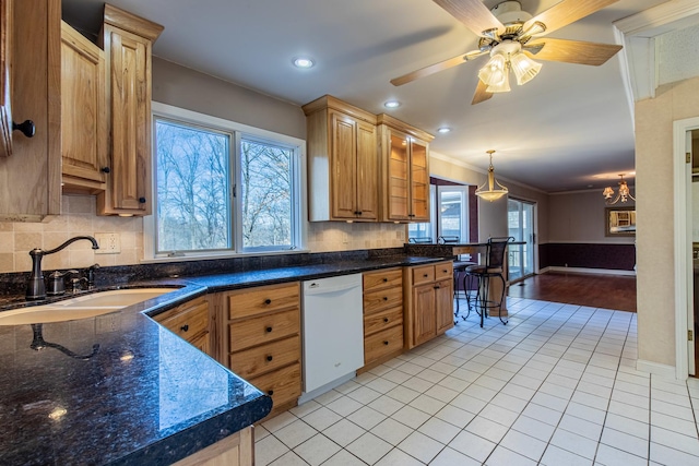 kitchen with light tile patterned flooring, a sink, dishwasher, crown molding, and backsplash