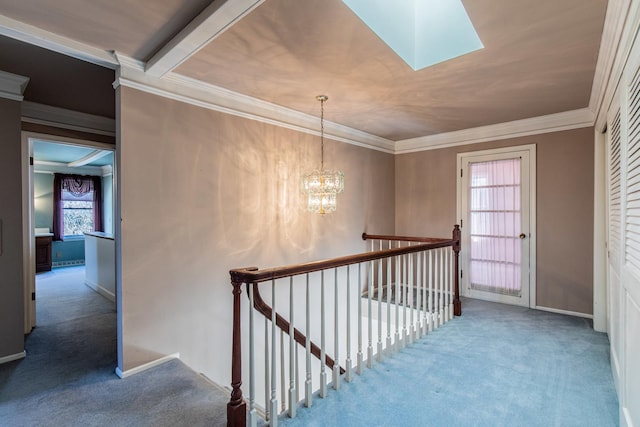 hallway featuring a skylight, carpet flooring, an upstairs landing, and a chandelier