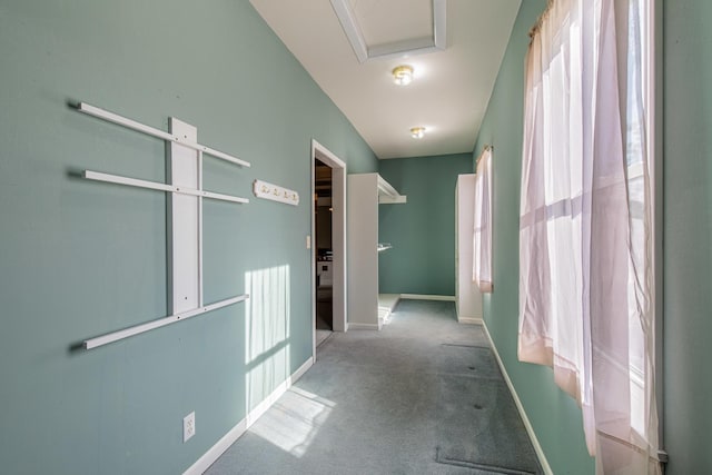 hallway featuring carpet flooring and baseboards