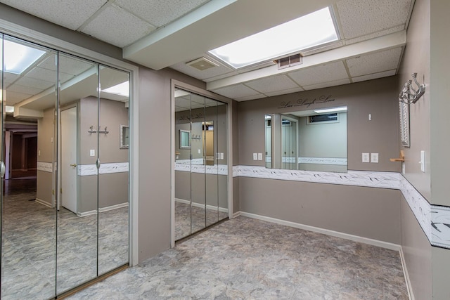 bathroom with visible vents, a paneled ceiling, and baseboards