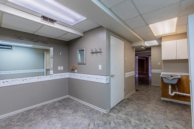 interior space featuring a drop ceiling, visible vents, and baseboards