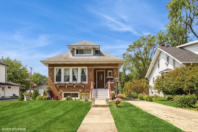 bungalow-style home featuring brick siding and a front yard