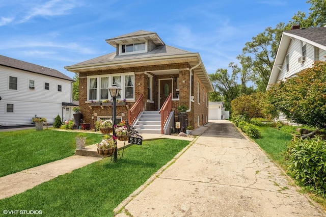 bungalow-style home with an outbuilding, a garage, brick siding, and a front lawn