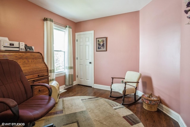 sitting room with baseboards and dark wood-style flooring