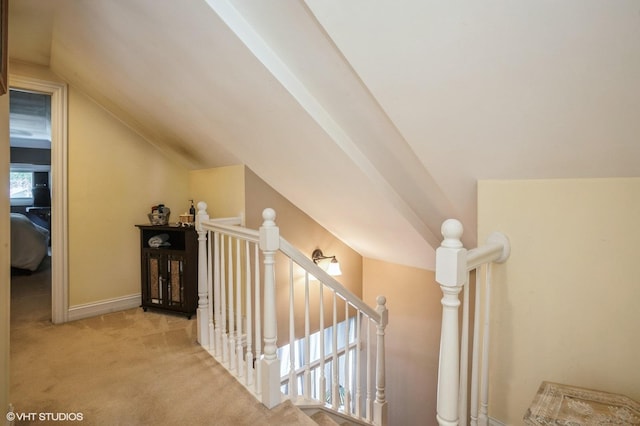 interior space with vaulted ceiling, carpet, and baseboards