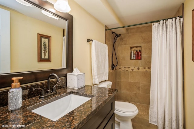 full bath featuring tiled shower, toilet, and vanity