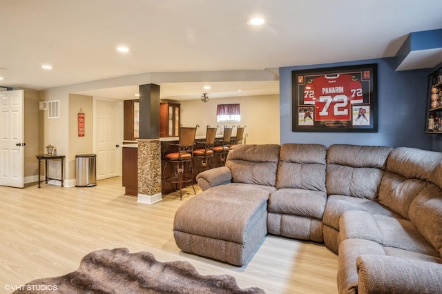 living room with visible vents, recessed lighting, a dry bar, and light wood-style floors