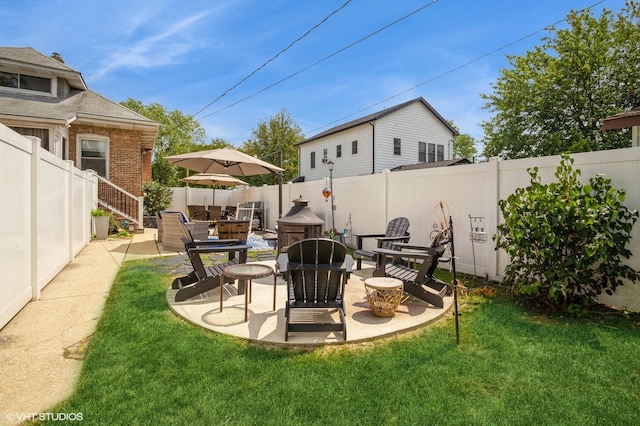 view of yard with a fire pit, a fenced backyard, and a patio area