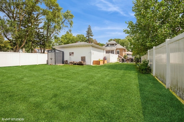 view of yard with an outbuilding, a fenced backyard, and a shed