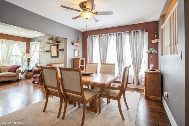 dining area with baseboards, wood finished floors, and a ceiling fan