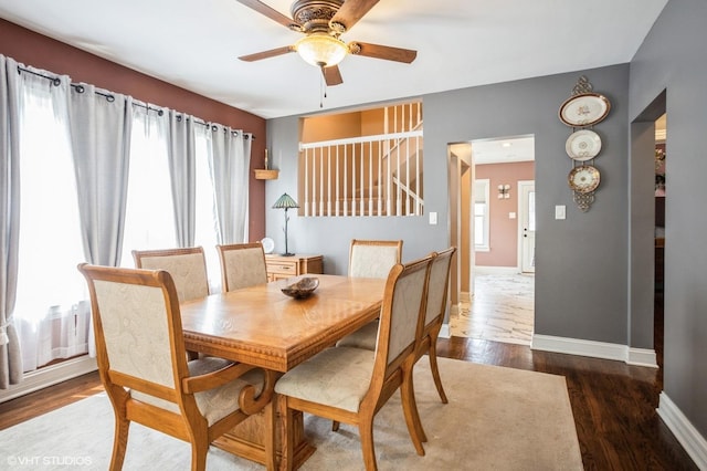 dining room featuring wood finished floors, baseboards, and ceiling fan