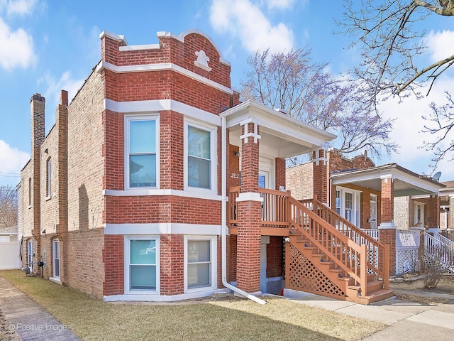 view of front facade with brick siding and a front lawn