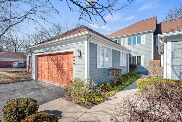 view of side of property featuring an outbuilding, driveway, and a garage