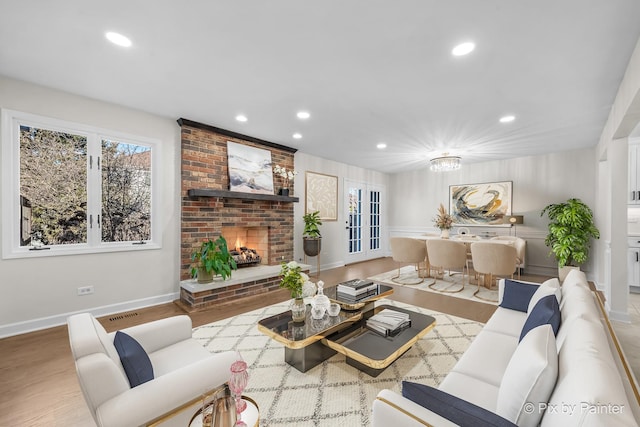 living area featuring recessed lighting, a fireplace, and wood finished floors