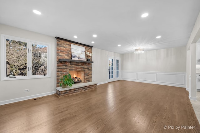 unfurnished living room featuring wood finished floors, recessed lighting, and a fireplace