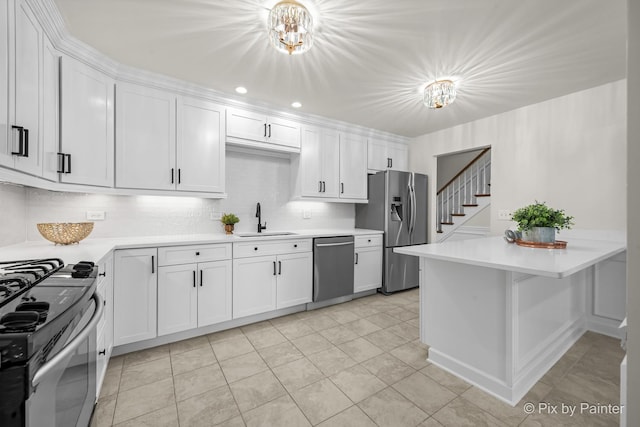 kitchen featuring a sink, stainless steel appliances, white cabinets, and light countertops