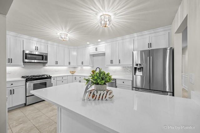 kitchen with white cabinets, backsplash, and stainless steel appliances