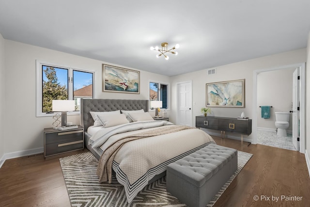 bedroom with a notable chandelier, baseboards, visible vents, and wood finished floors