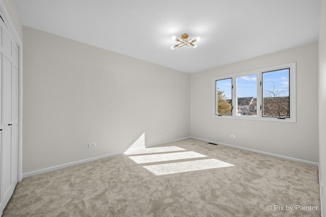 unfurnished bedroom with a closet, baseboards, carpet, and visible vents