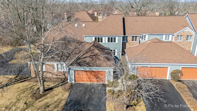 view of front facade with aphalt driveway and a shingled roof