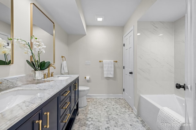 bathroom featuring a sink, baseboards, toilet, and double vanity