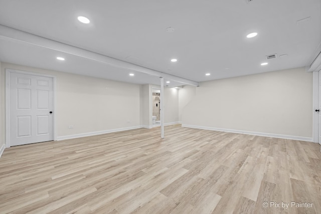 finished below grade area featuring recessed lighting, visible vents, baseboards, and light wood finished floors