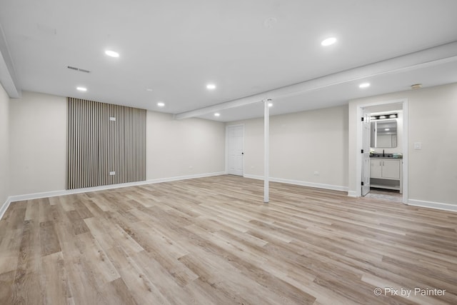 finished basement with light wood-style flooring, recessed lighting, baseboards, and visible vents