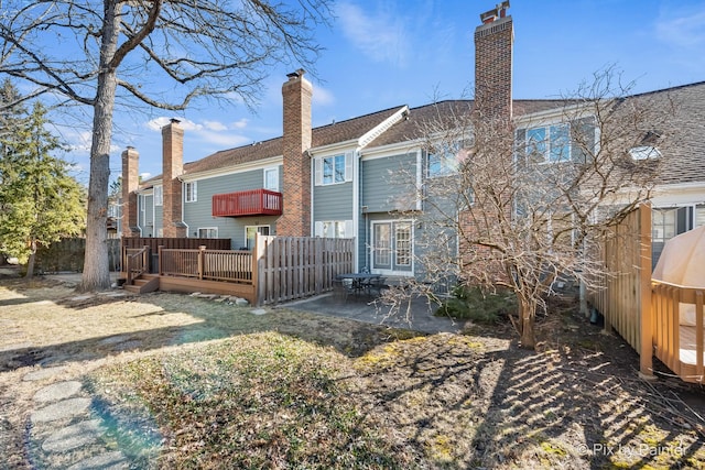 back of house featuring a patio, a deck, and a chimney