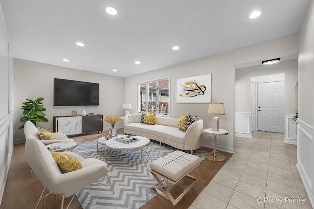 living area featuring a decorative wall, light tile patterned floors, recessed lighting, and a wainscoted wall