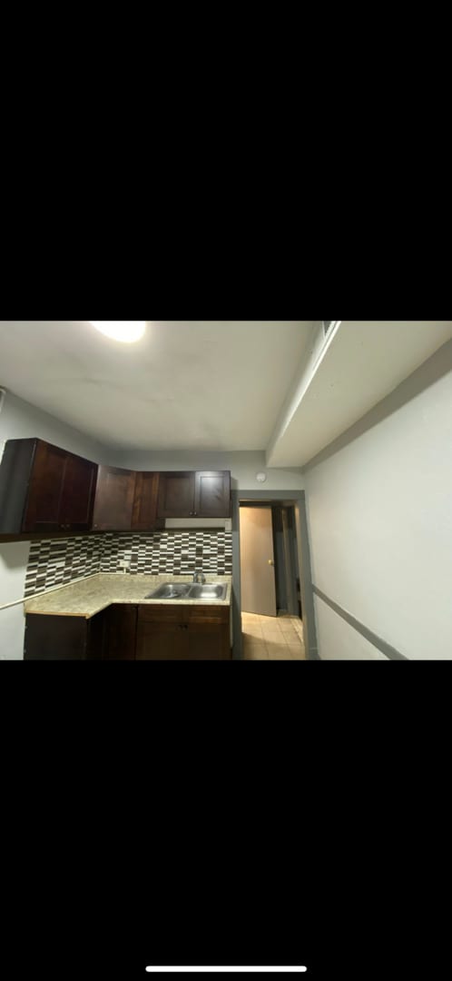 kitchen featuring dark brown cabinetry, backsplash, and a sink