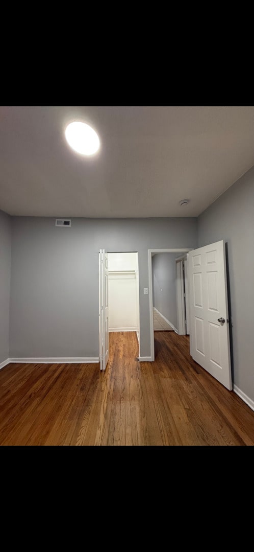 interior space featuring wood finished floors, visible vents, and baseboards