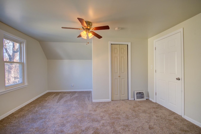 additional living space featuring baseboards, carpet floors, visible vents, and vaulted ceiling