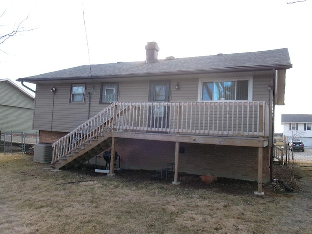 rear view of house with a wooden deck, central AC, fence, a yard, and stairway