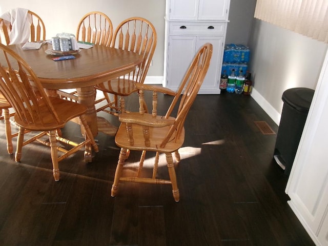 dining space with dark wood-type flooring and baseboards