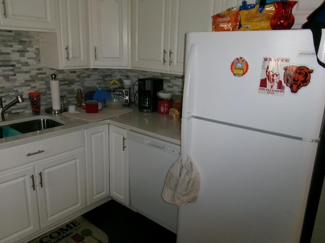 kitchen with a sink, backsplash, white appliances, white cabinets, and light countertops