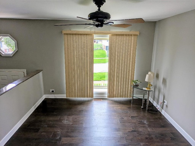 interior space with baseboards, a ceiling fan, and wood finished floors