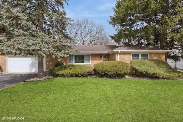 single story home with a front lawn, brick siding, and aphalt driveway