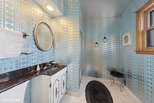 full bath with tile patterned flooring, vanity, and wallpapered walls