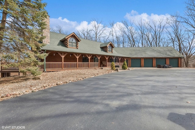 cabin featuring covered porch and driveway