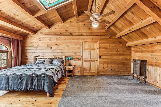 bedroom featuring vaulted ceiling with skylight, wooden ceiling, and wood walls