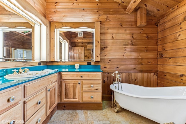 bathroom featuring vanity, a freestanding bath, vaulted ceiling, wood ceiling, and wood walls