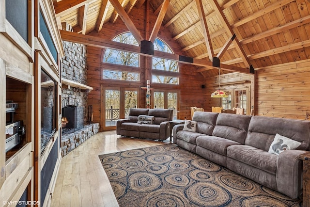 living room featuring a fireplace, hardwood / wood-style flooring, wood walls, wooden ceiling, and beamed ceiling