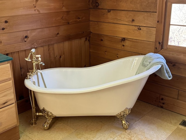 full bath featuring a freestanding bath and wood walls