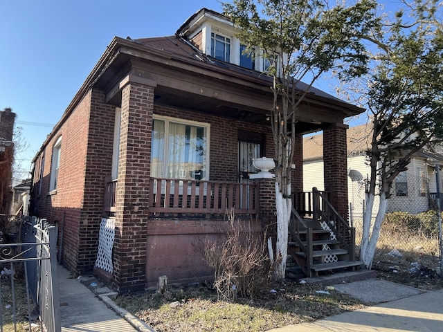 view of front facade with covered porch and brick siding