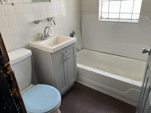 full bathroom with vanity, tile walls, and toilet