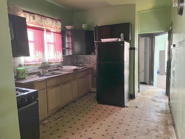 kitchen featuring a sink, open shelves, range with gas stovetop, and freestanding refrigerator